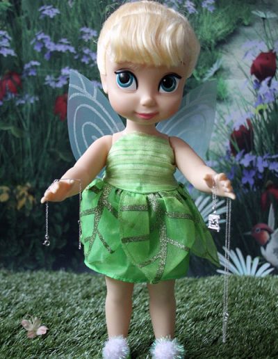 photo - baptême - zoom souvenirs - poupée - collier - bracelet - pelouse - clochette - décor - vert - gris - ailes