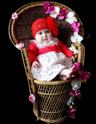 photo - bébé - zoom souvenirs - studio - fauteuil - fleurs - robe - bonnet - sourire - rouge - blanc - rose - marron