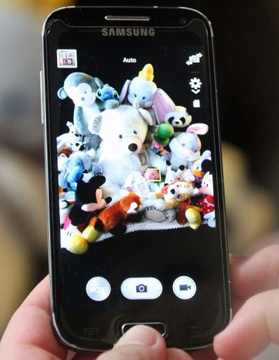 photo - bébé - zoom souvenirs - peluche - téléphone - main - noir - bleu - marron
