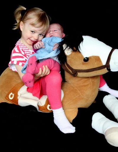 photo - bébé - zoom souvenirs - fratrie - sourire - peluche - robe - couette - cheval - noir - marron - rose - bleu