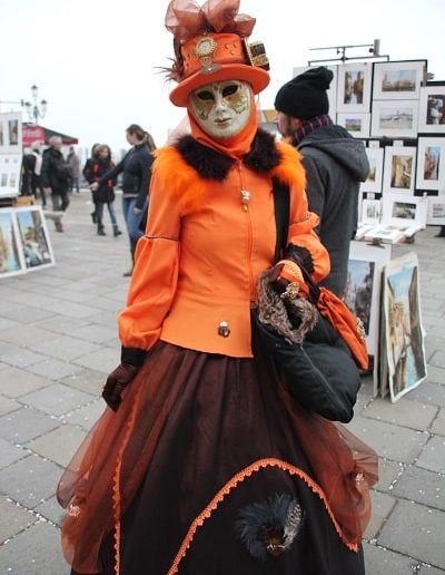 photo - carnaval de venise - zoom souvenirs - femme - robe - chapeau - sac - tulle - tableau - foulard - veste - gant - déguisement - masque - orange - marron - noir