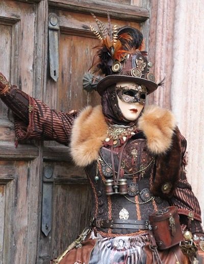 photo - carnaval de venise - zoom souvenirs - plume - chapeau - déguisement - femme - robe - veste - masque - lunette - marron -
