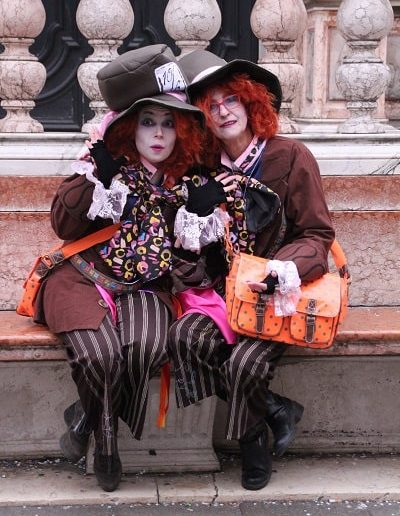 photo - carnaval de venise - zoom souvenirs - couple - déguisement - maquillage - roux - perruque - chapeau - sac - rayure - gant - chapelier - cravate - marbre - banc - marron - noir - motif - dentelle