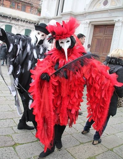 photo - carnaval de venise - zoom souvenirs - plume - masque - hommes - corbeau - ailes - chapeau - rouge - noir - blanc - gant