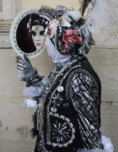 photo - carnaval de venise - zoom souvenirs - femme - déguisement - plume - miroir - reflet - gant - veste - noir - argenté - chapeau - bijoux