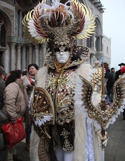 photo - carnaval de venise - zoom souvenirs - plume - déguisement - masque - homme - cepstre - bouclier - cape - chapeau - église - touriste - blanc - doré - marron