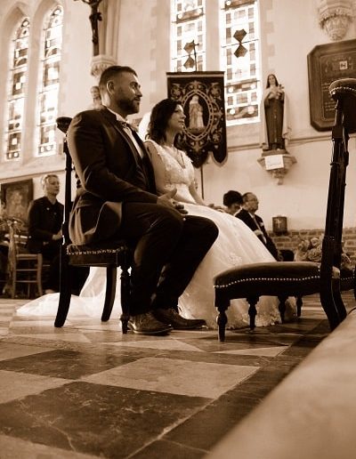 photo - mariage - zoom souvenirs - couple - église - robe - costume - croix - chaise - vitraux - statue - sépia - carrelage - sourire