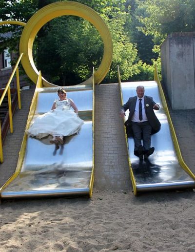 photo - mariage - zoom souvenirs - couple - tobogan - rire - robe - costume - sable - parc - jaune - gris - blanc