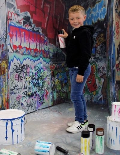 photo - scolaire - zoom souvenirs - enfant - sourire - garçon - pot - pinceau - rouleau - décor - graffiti - peinture - rouge - bleu - noir