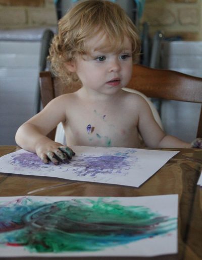 photo - thématique - zoom souvenirs - bébé - peinture - salir - dessein - boucle - fille - blonde - chaise - violet - feuille - bleu - marron