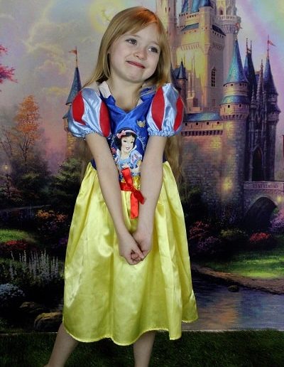 photo - thématique - zoom souvenirs - fille - princesse - château - pelouse - décor - enfant - déguisement - jaune - sourire - rouge - bleu - vert