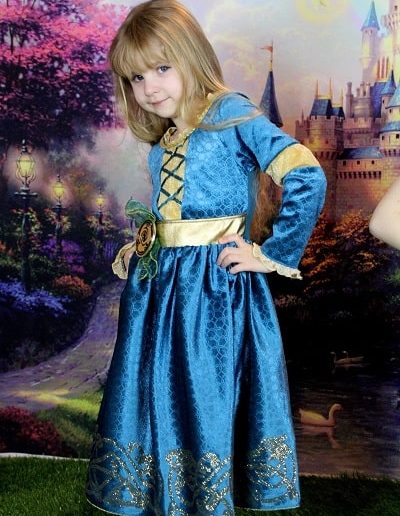 photo - thématique - zoom souvenirs - enfant - princesse - robe - château - pelouse - fille - décor - bleu - dentelle - sourire - vert - doré
