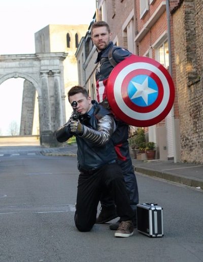 photo - thématique - zoom souvenirs - hommes - déguisement - rue - captain america - valise - bouclier - combinaison - fusil - combinaison - ciel - rouge - soldat - bleu - noir - étoile