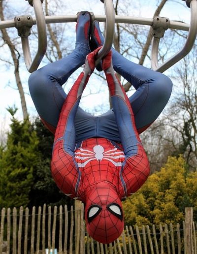 photo - thématique - zoom souvenirs - homme - déguisement - araignée - accroché - masque - combinaison - arbre - ciel - spiderman - vert - bleu - rouge - barrière - branche