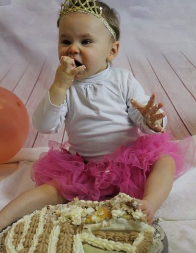 photo - smash the cake - zoom souvenirs - bébé - gâteau - anniversaire - tutu - maillot - manger - couronne - ballon - sourire - rose - blanc