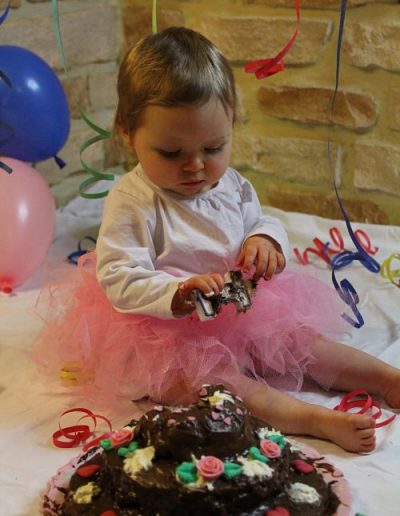 photo - smash the cake - zoom souvenirs - fille - gâteau - anniversaire - bougie - tutu - chocolat - maquillage - serpentin - ballons - rose - bleu - blanc - marron