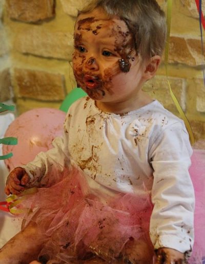 photo - smash the cake - zoom souvenirs - fille - gâteau - anniversaire - chocolat - maquillage - ballon - tutu - rose - blanc - serpentin - marron