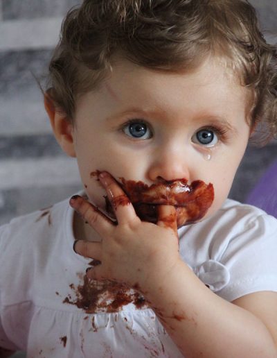 photo - smash the cake - zoom souvenirs - fille - gâteau - anniversaire - chocolat - maquillage - boucles - gris - blanc - marron