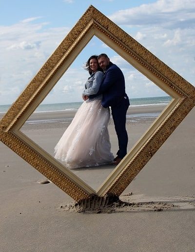 photo - trash the dress - zoom souvenirs - couple - mariage - soleil - cadre - sourire - robe - sable - costume - ciel - mer - dentelle - bleu - marron - blanc