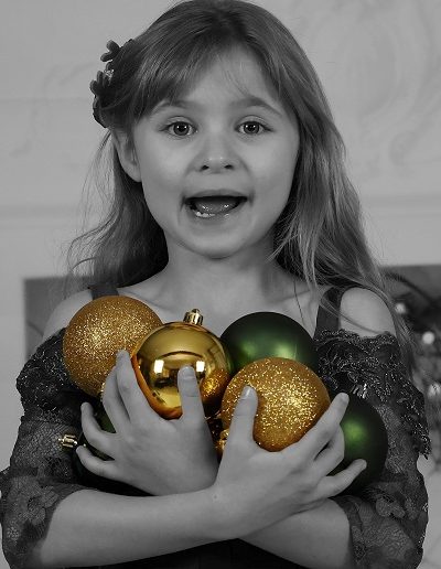 photo - thématique - zoom souvenirs - fille - noël - décor - boules - sourire - robe - noir et blanc - couleur - or - vert