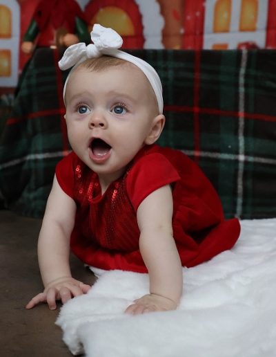 photo - thématique - zoom souvenirs - bébé - noël - robe - sourire - bandeau - couverture - décor - rouge - blanc - vert
